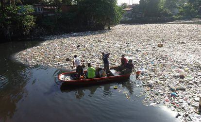 Un grupo de ciudadanos limpia un río de plásticos en Filipinas.