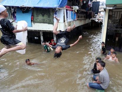 Varios niños juegan a tirarse al agua en una calle inundada de Yakarta, capital de Indonesia, el 25 de febrero.