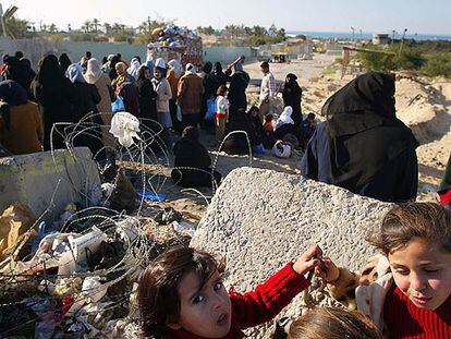 Mujeres y niñas palestinas ante el control militar que separa Muasai del campo de refugiados de Jan Yunis.