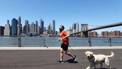 Un hombre corre con su perro en Brooklyn, Nueva York.