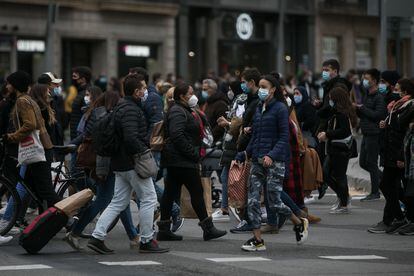 Decenas de personas cruzan el paso de peatones en el centro de Barcelona