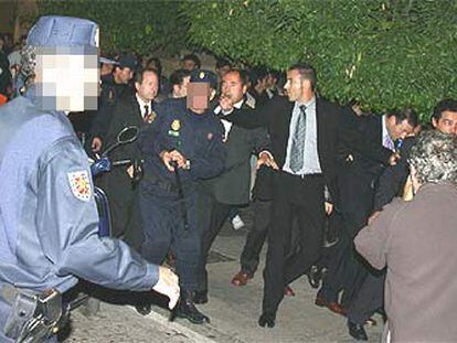Agentes del Cuerpo Nacional de la Policía protegen al <i>lehendakari,</i> a la derecha, ante los intentos de agresión de un grupo de ultraderechistas.