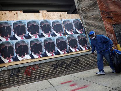 Un hombre camina frente a anuncios de Trump en las calles de Washington.