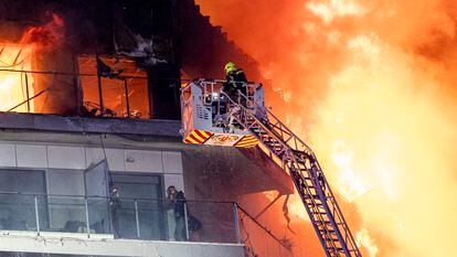 Los bomberos atacan el incendio en un edificio de 14 plantas en el barrio de Campanar.