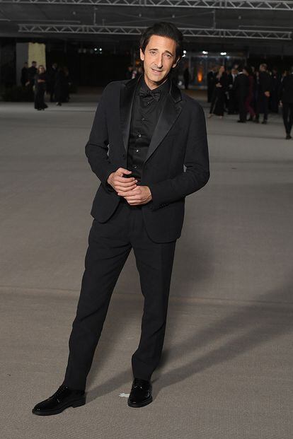 Adrien Brody, con traje, camisa y pajarita en negro.