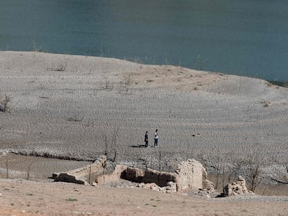 Dos personas caminan por el embalse de Sau (Girona), el 16 de abril de 2023.