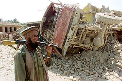 Un afgano armado vigila las ruinas del edificio que sufrió la explosión en Jalalabad.