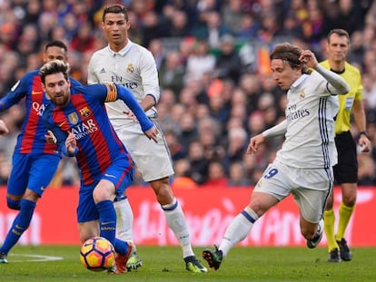 Leo Messi lleva el bal&oacute;n ante Cristiano Ronaldo y Luka Modric, en un Barcelona-Real Madrid de La Liga espa&ntilde;ola.