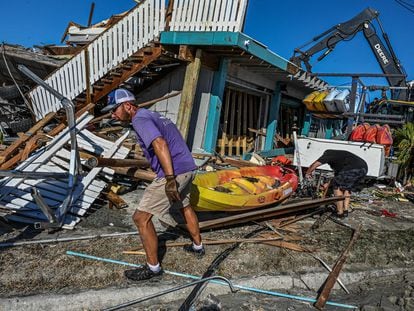 Trabajadores y residentes limpian los escombros de un bar destruido en la isla de San Carlos, en Fort Myers (Florida), este sábado.