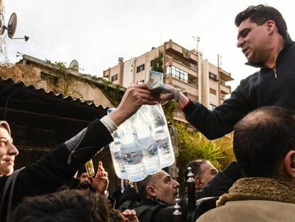 Un hombre vende botellas de agua mineral en un barrio de Damasco.