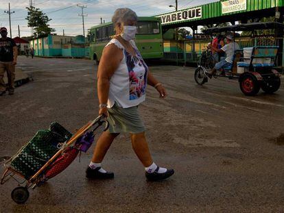 Una mujer con mascarilla camina por una calle de San José de las Lajas (Cuba) con un carrito de la compra el pasado 18 de junio de 2020.