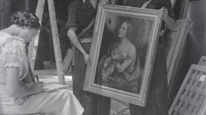 Una mujer hace el inventario de los cuadros de Las Descalzas Reales con dos soldados republicanos en 1936.