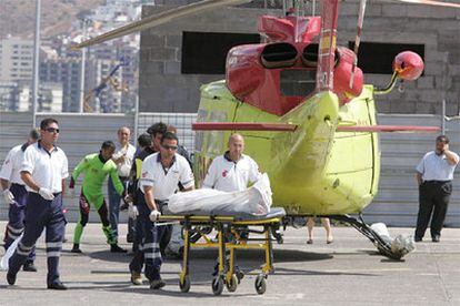 Miembros del Servicio de Urgencias trasladan en camilla uno de los cuatro cadáveres que viajaban en el helicópteros siniestrado.