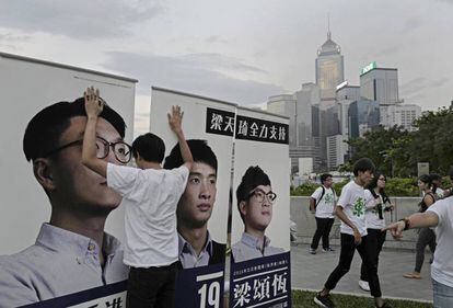 Un ciudadano sujeta varios carteles electorales en Hong Kong.