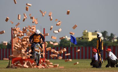 Un soldado indio de la armada americana, miembro del equipo de motociclismo, conduce a través de un muro de ladrillos, en la Academia de Entrenamiento de Chennai (India).