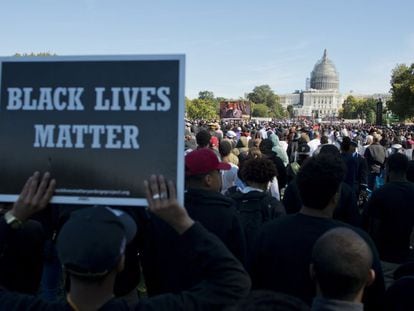 Un asistente lleva un cartel del movimiento 'Las vidas negras importan' durante las protestas por las muertes de negros desarmados a manos de la policía en Estados Unidos