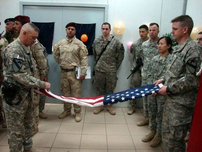 Soldados de EEUU doblan la bandera antes de abandonar su base.