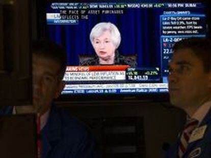 Operadores en la Bolsa de Nueva York escuchan el discurso de Yellen.
