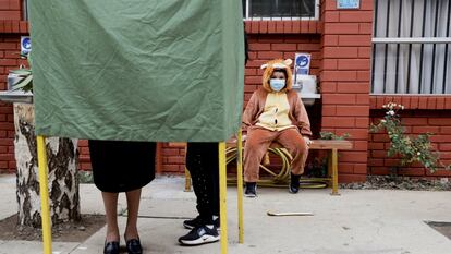 Un niño observa a su madre emitir su voto en Temuco, Chile, el pasado 17 de mayo.