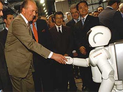 El rey Juan Carlos I saluda a Asimo, el robot humanoide de Honda.