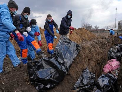 FILE - Dead bodies are placed into a mass grave on the outskirts of Mariupol, Ukraine, Wednesday, March 9, 2022, as people cannot bury their dead because of the heavy shelling by Russian forces. (AP Photo/Evgeniy Maloletka, File)