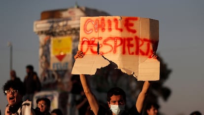 Un manifestante sostiene un cartel con la frase "Chile despierta", durante una protesta para exigir un nuevo proceso constituyente, en Santiago, el 5 de septiembre de 2022.