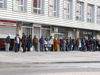 Varias personas forman fila ante una oficina del INEM.