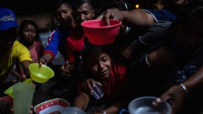 Indígenas venezolanos de la etnia Warao se congregan para distribuir alimentos antes de una sesión de cine el 6 de abril de 2019 en Pacaraima, Brasil.