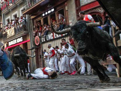 Los mozos corren ante los toros de la ganadería de José Escolar durante el tercer del encierro de San Fermín, este sábado.