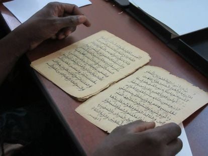 Gente leyendo algunos de los 377.000 manuscritos que se están restaurando y digitalizando, en Bamako (Malí).