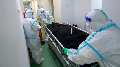 Personal sanitario transporta el cadáver de una mujer fallecida por coronavirus, el 15 de octubre, en el Instituto Nacional de Neumología Marius Nasta de Bucarest, Rumanía.