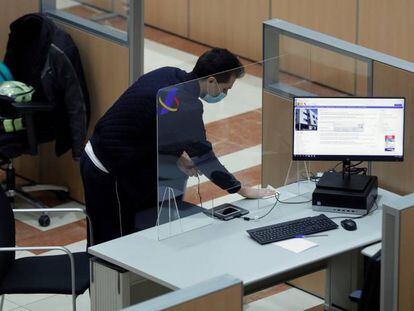 Un hombre desinfecta uno de los puestos dela sede de la delegación de Hacienda de Guzmán el Bueno en Madrid. 