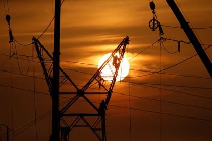 Los técnicos trabajan en una torre de electricidad durante el mantenimiento de las líneas eléctricas de alta tensión en Cantin (Francia).