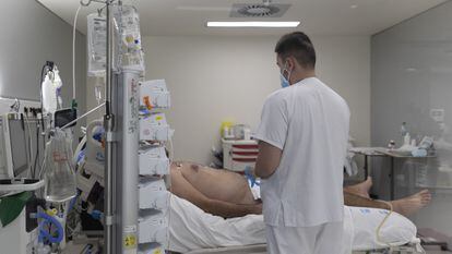 Un sanitario atiende a un paciente ingresado en la UCI.