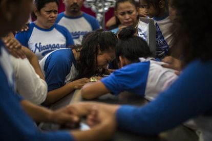 Amigos de Gerald Vázquez lloran sobre su ataúd durante su funeral.