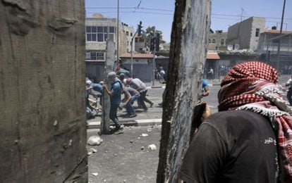 Jóvenes palestinos lanzan piedras a las fuerzas de seguridad israelíes en los disturbios tras el funeral del joven palestino asesinado.