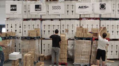 Trabajadores organizando las cajas con las papeletas en una nave industrial del polígono de La Garena, en Alcalá de Henares.