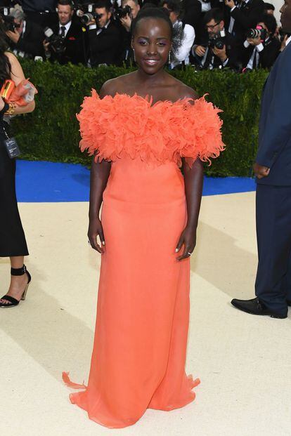 Lupita Nyong'o sabe que los colores vibrantes le favorecen. Este diseño naranja es de Prada.