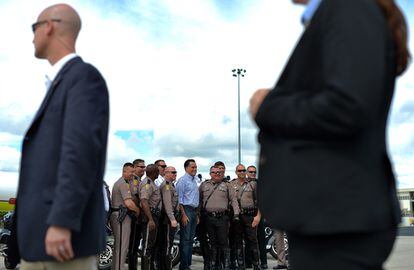 El candidato republicano se fotografía con policías en el aeropuerto de Orlando, antes de tomar su avión de campaña, el 7 de octubre.