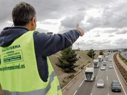 Un miembro de la Asociación de Transportistas en el puente de la M-45, durante el quinto día de paros en el sector de los transportes.