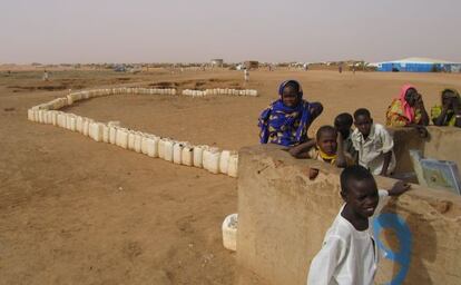 Varios ni&ntilde;os aguardan su turno ante uno de los pozos de agua potable del campo de refugiados de Abushok, en Darfur (Sud&aacute;n).