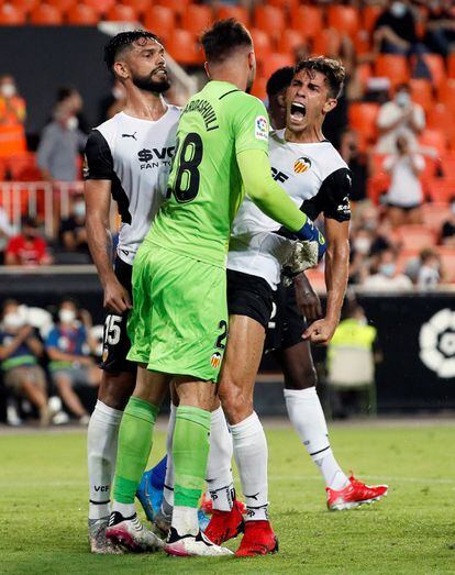 Los jugadores del Valencia, Gabriel Paulista (d) y Omar Alderete (i) felicitan a Mamardashvili al término del encuentro contra el Getafe.