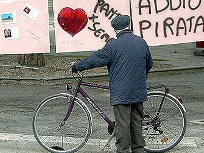 Un viejo ciclista se detiene ante carteles de recuerdo a Pantani en su ciudad, Cesenatico.