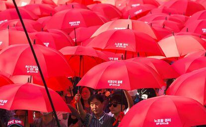 Manifestantes surcoreanos portan paraguas durante la manifestación del 1 de Mayo.