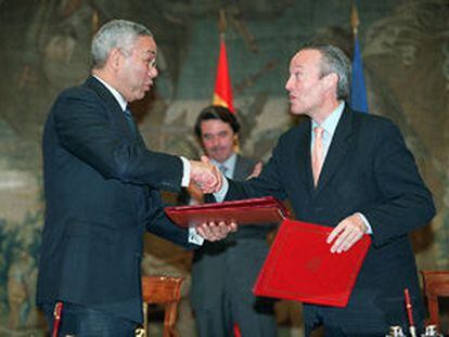 Colin Powell y Josep Piqué se dan la mano, en presencia de Aznar, tras firmar el nuevo convenio.
