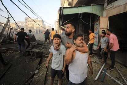 Dos niños lloran mientras prosigue la búsqueda de supervivientes de en un edificio residencial destruido por un ataque israelí en Gaza.