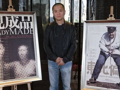 Zhang Bingjian, con dos carteles de sus obras.