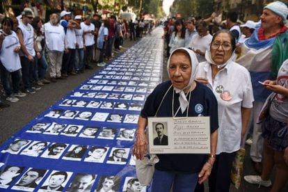 Madres de Plaza de Mayo junto a fotografías de desaparecidos en la dictadura argentina.