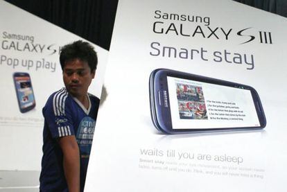 Un trabajador colocando unos paneles informativos sobre el Samsung Galaxy SIII
