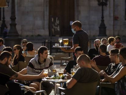 Un camarero atiende a los clientes de una terraza de un bar de Tarragona, este lunes.